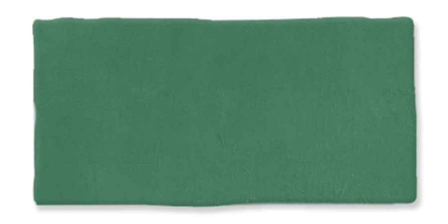 A rectangular piece of green modeling clay with a slightly uneven surface and rough edges, set against a white background.