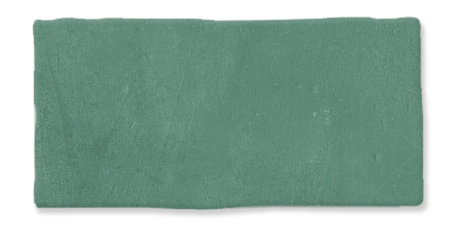 A rectangular ceramic tile with a matte green surface and slightly uneven edges against a white background.