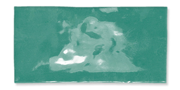 A rectangular ceramic tile in glossy turquoise with a subtle, uneven cloudy texture and slight variations in color across the surface.