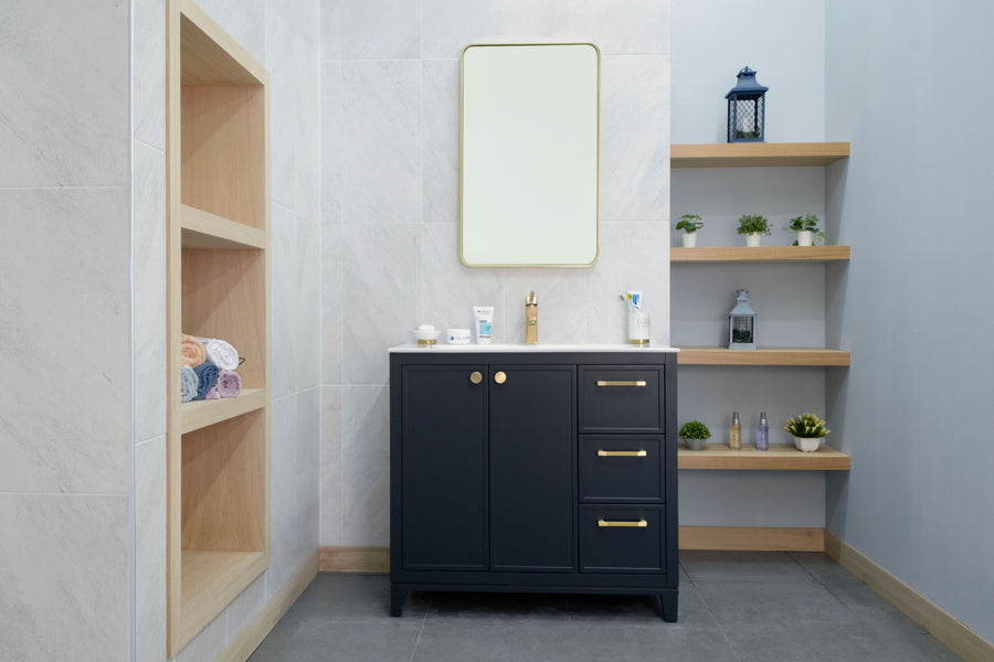 Modern bathroom featuring the Frame 36" Vanity in black with a gold faucet and above-mirror. Open wood shelves display plants, decor, and toiletries. Built-in shelves on the left store rolled towels. Light gray tile walls contrast with dark floor tiles.