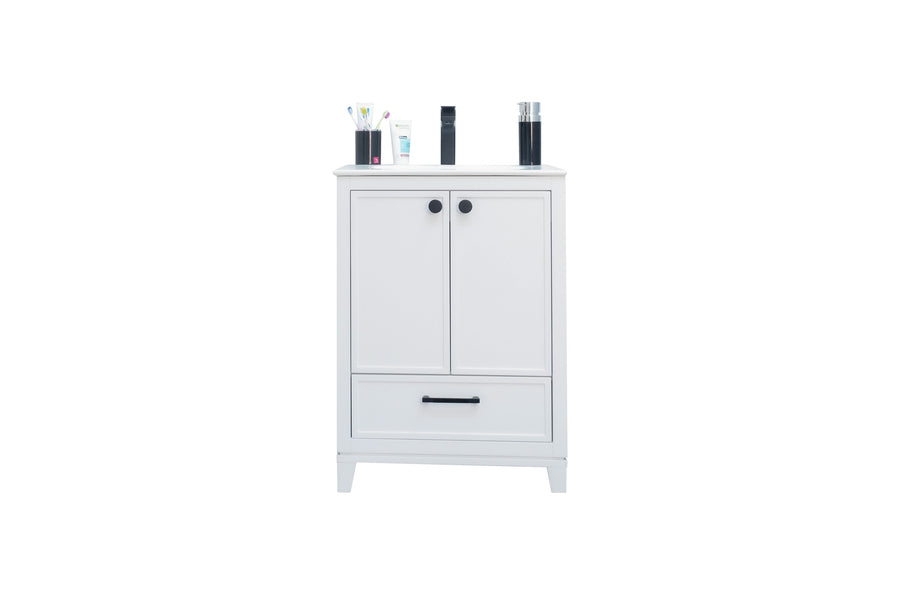 A white cabinet with two doors and a drawer, topped with various toiletries, including toothbrushes in a holder, bottles, and a cup, set against a plain white background.