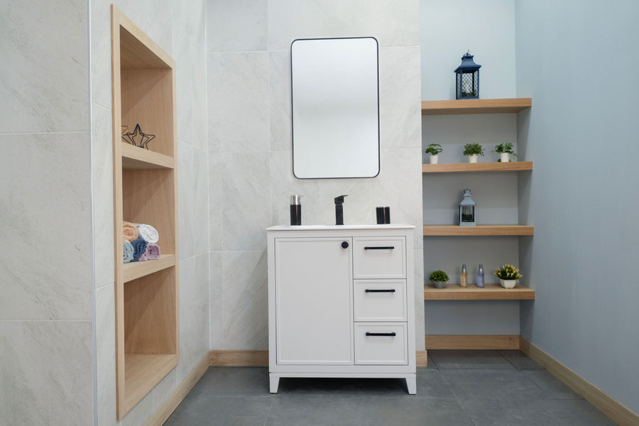 A modern bathroom featuring the Frame 30" Vanity, a rectangular mirror, open wooden shelves displaying plants and decor, built-in shelves with towels and accents, light walls, and a gray tiled floor for a sleek, stylish look.