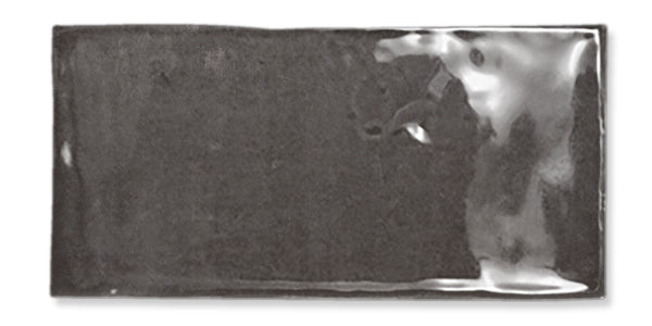 A rectangular, glossy, dark gray ceramic tile with a slightly uneven surface and a reflective sheen, set against a white background.