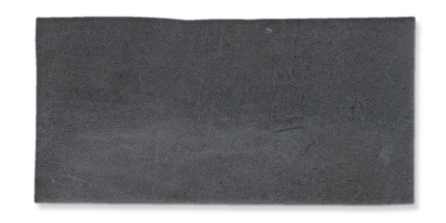 A rectangular slab of dark gray concrete or stone with a slightly uneven surface, viewed from above against a white background.