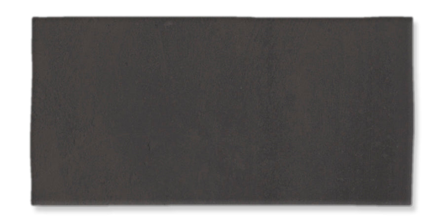 A rectangular, dark gray tile with a matte finish, set against a white background. The surface appears smooth with subtle variations in shading.