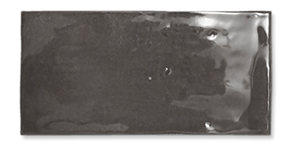 A shiny, rectangular, dark gray ceramic tile with slightly uneven surface texture and glossy finish, shown against a white background.
