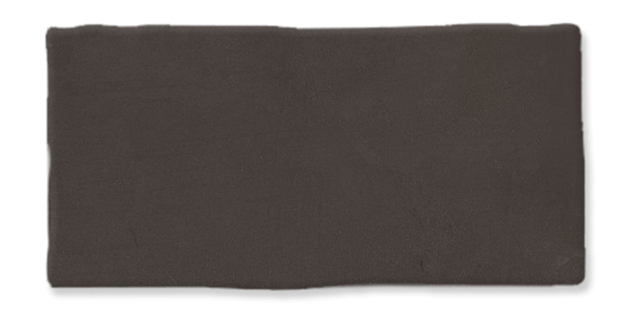 A rectangular, dark brown ceramic tile with a slightly uneven, handcrafted edge and a matte finish.