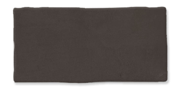 A rectangular, dark brown ceramic tile with a slightly uneven, handcrafted edge and a matte finish.