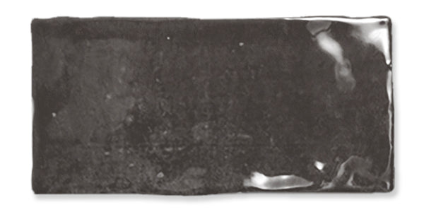 A rectangular, glossy black ceramic tile with slightly irregular edges and a reflective surface.