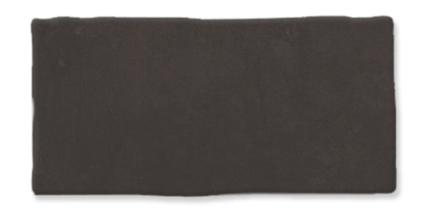 A rectangular piece of solid, dark brown clay or modeling material with slightly uneven edges, set against a white background.
