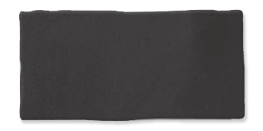 A rectangular slab of solid black material with slightly uneven edges, set against a white background.