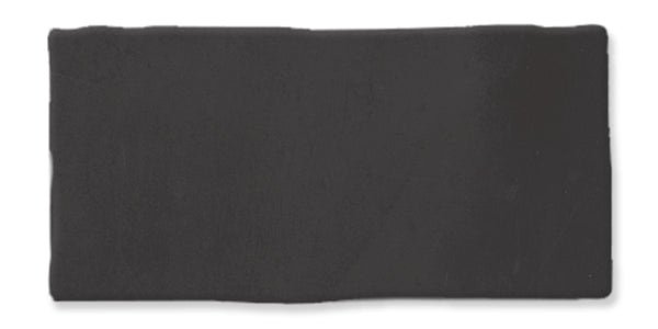 A rectangular slab of solid black material with slightly uneven edges, set against a white background.