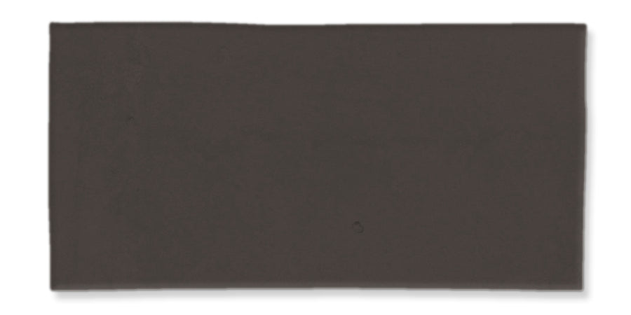 A rectangular, solid dark gray-black tile with a smooth surface and slightly uneven edges, set against a white background.