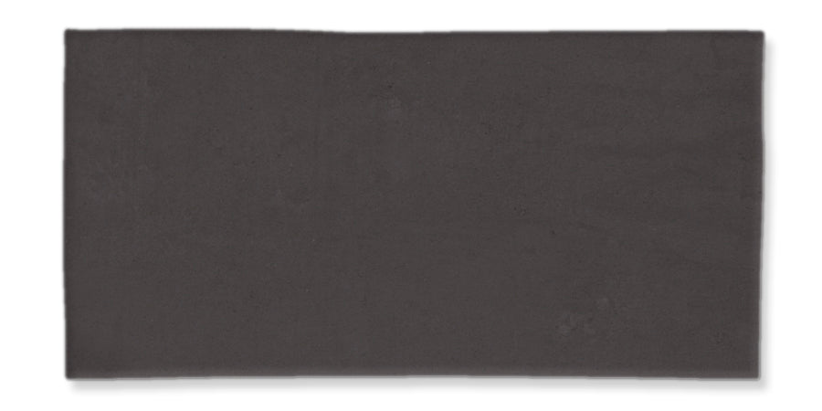 A rectangular, flat, dark gray tile with a smooth surface and slightly uneven edges, displayed against a white background.