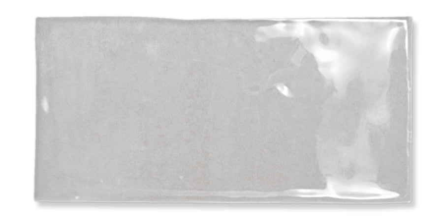 A rectangular, glossy light gray tile with a slightly uneven surface and reflective finish, set against a white background.