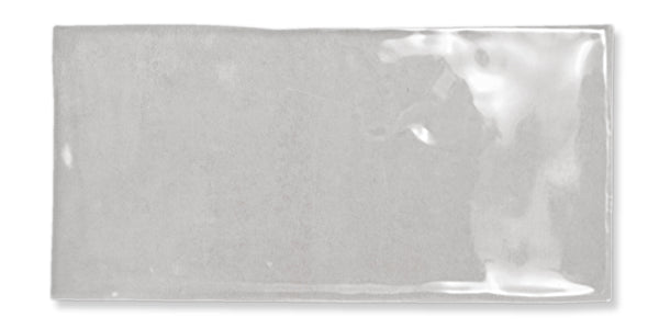 A rectangular, glossy light gray tile with a slightly uneven surface and reflective finish, set against a white background.