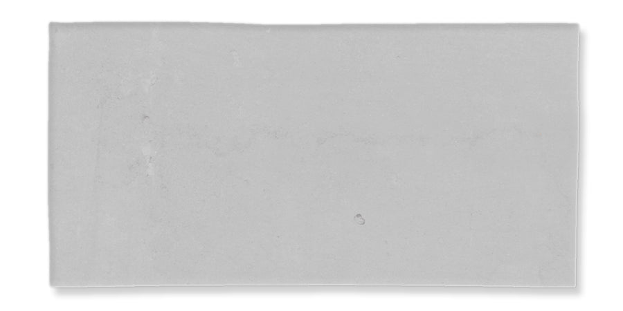 A rectangular, flat, light gray surface with a few faint marks and subtle texture, set against a white background.