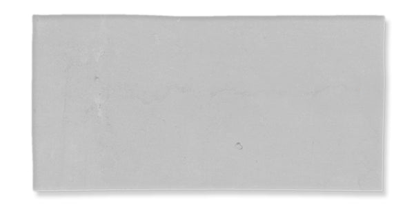 A rectangular, flat, light gray surface with a few faint marks and subtle texture, set against a white background.