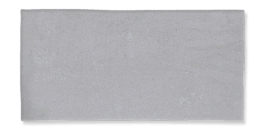 A rectangular, light gray tile with a smooth, matte surface and slightly uneven edges, displayed against a white background.