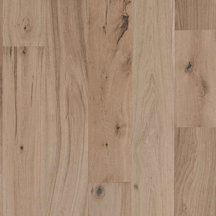 Close-up of Main Street 7 1/2" White Oak Hardwood featuring a light brown finish, visible grain patterns, knots, and subtle color variations between planks.