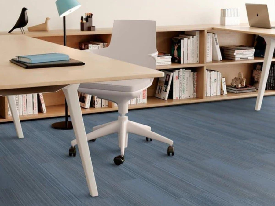 A desk with a chair and a bookshelf rests on Commercial Modular Carpet Tiles, ideal for any modern workspace.