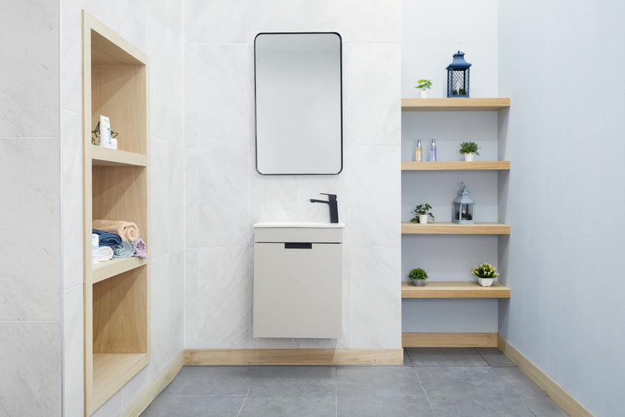 Modern bathroom with light-colored walls, a wall-mounted Luca 20" Vanity and black faucet, a rectangular mirror above, built-in wooden shelves on the left with towels, and floating wooden shelves on the right holding plants and decor.