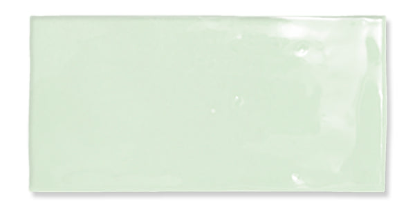 A glossy, rectangular, light mint green tile with a smooth surface and slightly uneven edges, set against a white background.