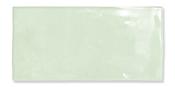 A rectangular, glossy light green ceramic tile with a smooth surface and subtle color variations.