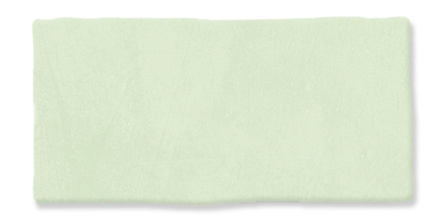 A rectangular, light green textured brushstroke on a white background.