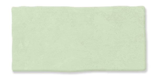 A rectangular, light green tile with a slightly uneven, textured surface and softly irregular edges.
