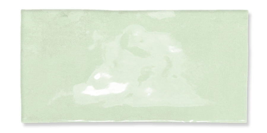 A rectangular, glossy, light green tile with a slightly uneven surface and subtle color variations.