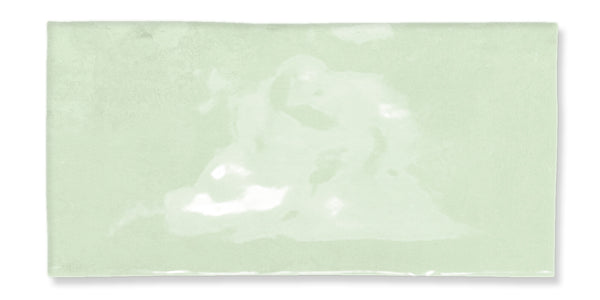 A rectangular, glossy, light green tile with a slightly uneven surface and subtle color variations.