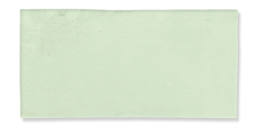 A rectangular, light green bath towel is laid flat on a white background. The towel appears soft and has a smooth texture with minimal visible pattern or detail.