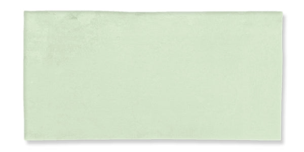 A rectangular, light green bath towel is laid flat on a white background. The towel appears soft and has a smooth texture with minimal visible pattern or detail.