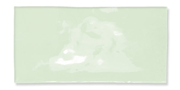 A glossy, rectangular pale green ceramic tile with a slightly uneven surface and smooth edges, photographed against a white background.