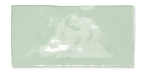 A rectangular, glossy, light green ceramic tile with subtle color variations and a slightly uneven surface texture.