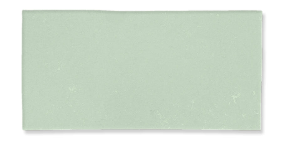 A rectangular, light green tile with a smooth, matte surface and subtle texture variations.