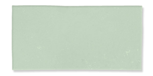 A rectangular, light green tile with a smooth, matte surface and subtle texture variations.