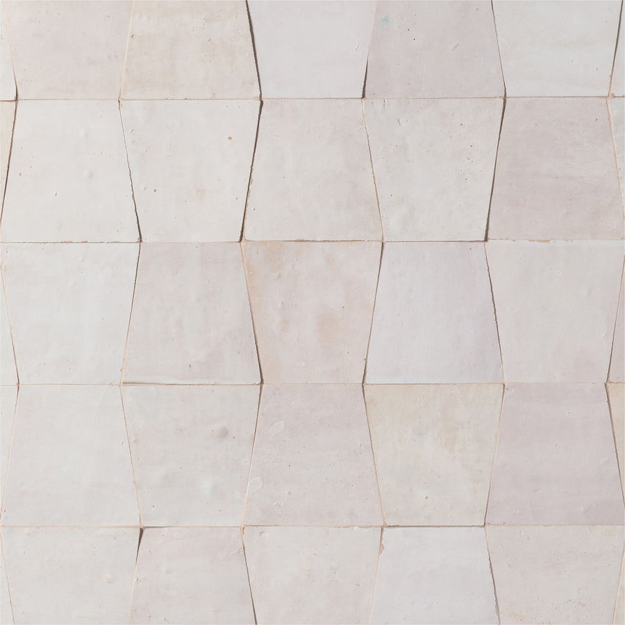 A wall of light beige, hexagonal tiles forms a geometric and textured surface using the elegant Mistral Trapezoid 3x4 Tile.