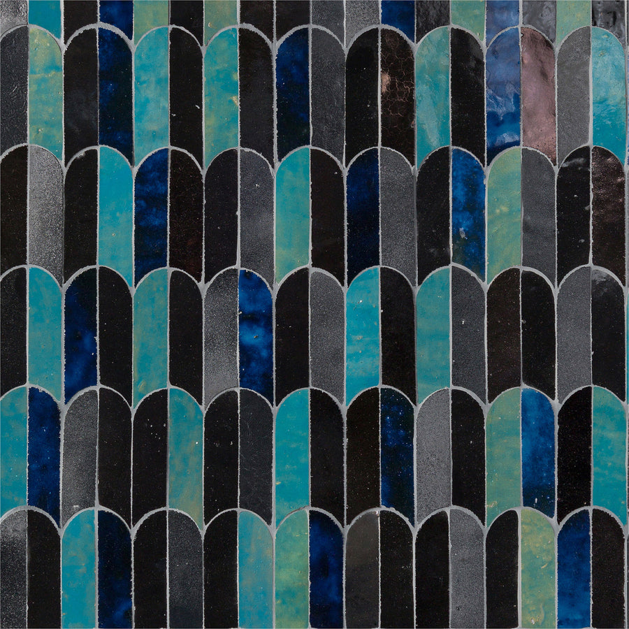 The Mistral Bab Mosaic features distinctive curved, arch-shaped tiles in black, blue, teal, and dark green, showcasing artistic elegance through its unique repeating and overlapping design.