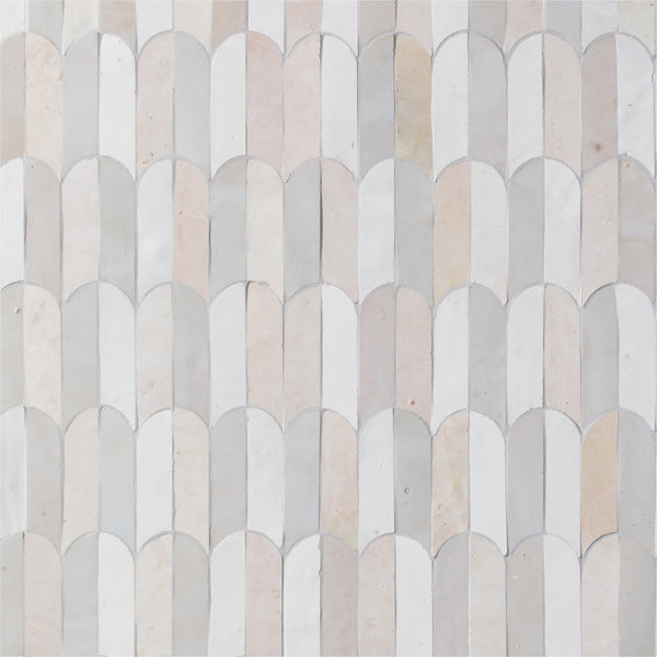 The Mistral Bab Mosaic features a repeating scallop pattern of curved tiles in an exclusive blend of white, cream, and pale gray, bringing artistic elegance to any space.