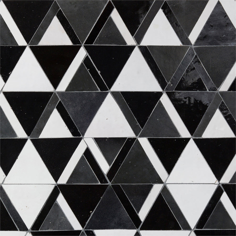 The Mistral Kilim Mosaic features a repeating geometric pattern of black, white, and gray triangles on tiled surfaces for a sophisticated look.