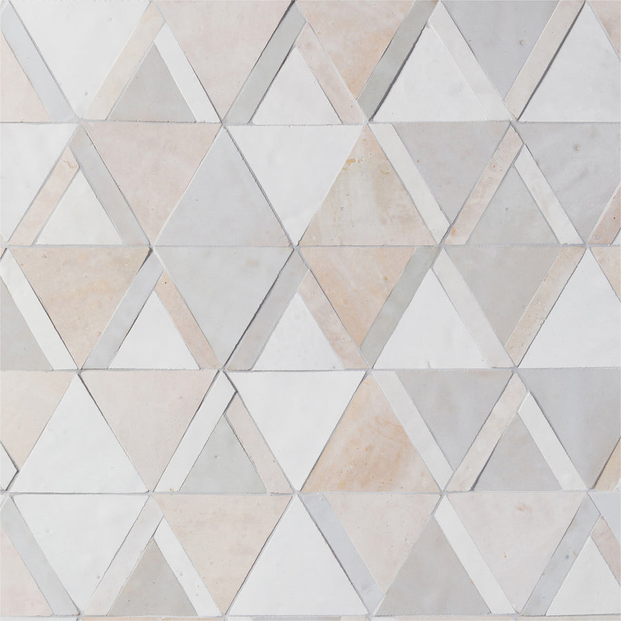 The Mistral Kilim Mosaic features light-colored marble tiles in a geometric triangle pattern, forming hexagons with shades of white, beige, and light gray for a sophisticated look.