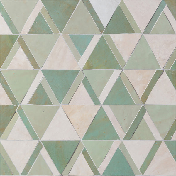 The Mistral Kilim Mosaic features a geometric pattern of green and off-white triangles in a repeating mosaic, creating a symmetrical and visually textured luxury piece.