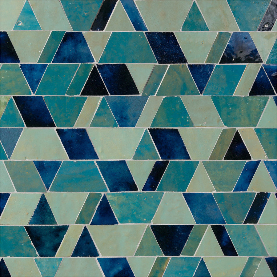 The Mistral Reverie Mosaic showcases exclusive elegance with its geometric pattern of blue, teal, and navy tiles in repeating triangles and parallelograms for an abstract, modern look.