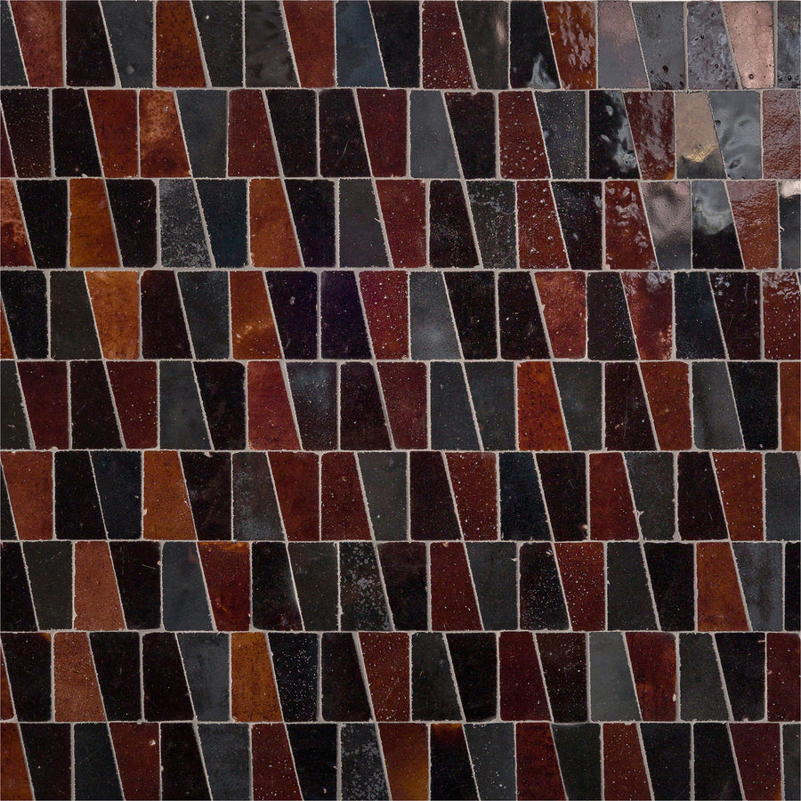 The Mistral Trapezium Mosaic features glossy, irregular tiles in dark red, brown, and black shades with a staggered geometric pattern—ideal for adding elegant style to your home decor.