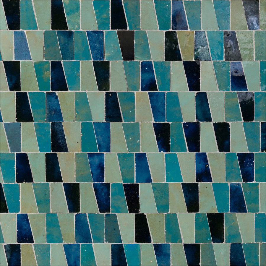 The Mistral Trapezium Mosaic features rectangular tiles in blue, teal, and turquoise shades, offering a glossy finish and subtle color variations for an elegant, luxurious touch to your home decor.