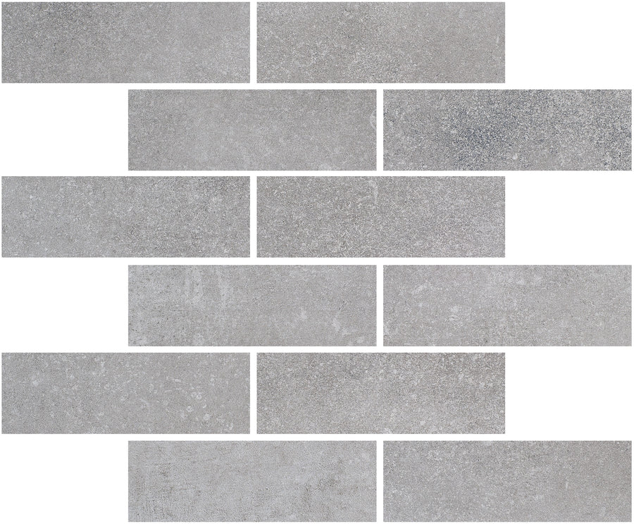 Ardennes Interlocking Mosaic Tile in Cliff features rectangular gray tiles with a subtle, textured surface and shade variations, arranged in an offset brick pattern on a white background.