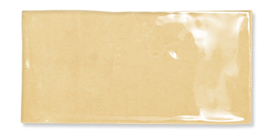 A rectangular, transparent plastic packet containing a light brown substance, possibly sauce or condiment, lying on a white background.