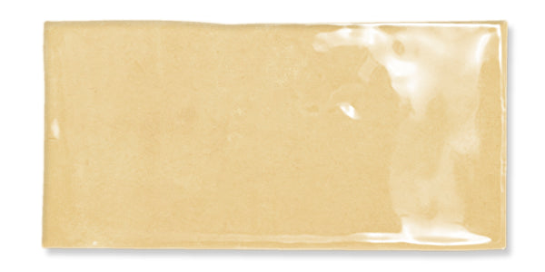 A rectangular, transparent plastic packet containing a light brown substance, possibly sauce or condiment, lying on a white background.